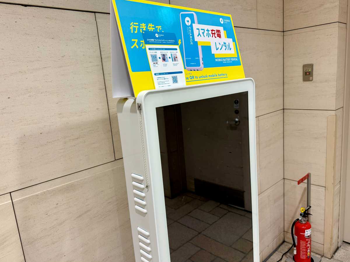 Phone charging or mobile battery rental sign near Tokyo Station